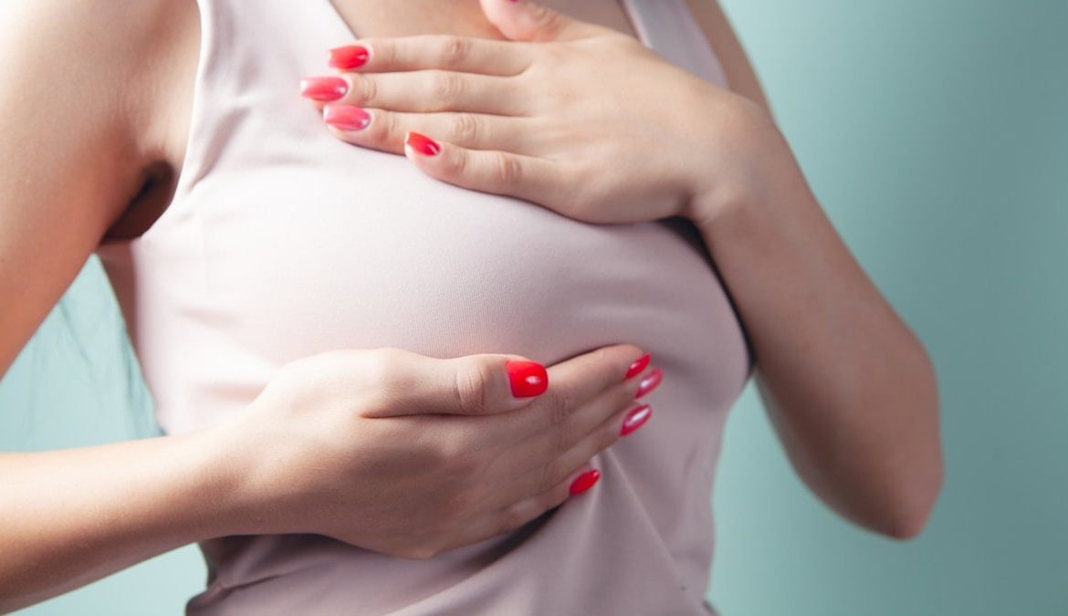a woman with red nail polish holding her stomach