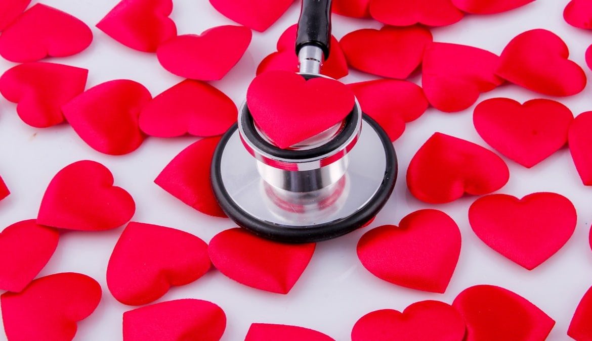 a stethoscope surrounded by hearts on a white surface